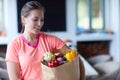 Becoming fit is exercising but more about what you eat. a young attractive woman carrying a bag of groceries at home. Royalty Free Stock Photo