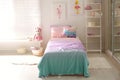 Bed with beautiful linens in children`s room