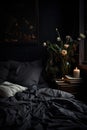 Bed With Black Comforter and Vase of Flowers