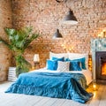 Bed with blue pillows and coverlet near fireplace against white brick wall. Loft, scandinavian interior design of modern bedroom Royalty Free Stock Photo