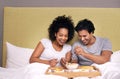 Bed, breakfast and couple with smile for fruit, nutrition and healthy with food for eating in morning. Bedroom, man and Royalty Free Stock Photo