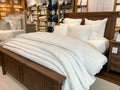 A bed with comforter, sheets, and pillows for sale at a Pottery Barn at an indoor mall in Orlando, Florida