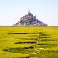 The bed of a dried-up stream snaking in the salt meadow opposite the Mont Saint-Michel tidal island in Normandy, France Royalty Free Stock Photo