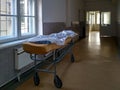 A bed in a hospital corridor. A medical facility with an empty bed