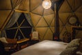 Bed and the interior of dome in luxury glamping hotel close to National Park Torres del Paine, Chile