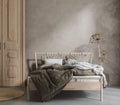 Bed with linen bedding, dry plant and wooden door in bedroom, room in natural tones