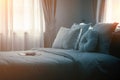 Bed maid-up with clean white pillows and bed sheets in beauty room. Close-up. Lens flair in sunlight. Royalty Free Stock Photo