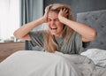 In bed in the morning with stress, angry and agro woman. Depressed girl in bedroom, hands on head and screaming in pain Royalty Free Stock Photo