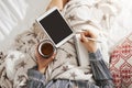 Bed is my office. High angle shot of girl lying in cozy atmosphere, listening music in earphones, holding tablet and Royalty Free Stock Photo