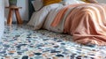 A View of a Bed With a Peach-Colored Blanket Resting on a Terrazzo Floor Royalty Free Stock Photo