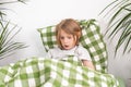 Bed rotting. With his tablet in hand, the young lad sits comfortably on the bed, exploring the internet at his pace Royalty Free Stock Photo