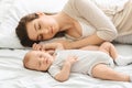 Adorable infant child sleeping with his mom in bedroom