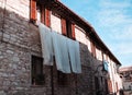 Bed sheets hung out to dry outside the window of an old stone house in a medieval Italian village Gubbio, Umbria, Italy Royalty Free Stock Photo