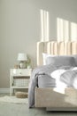 Bed with silky linens in room Royalty Free Stock Photo