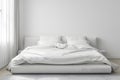 a bed with white bedding on a white wall background, the concept of preparing for the winter season,household chores,comfort in Royalty Free Stock Photo