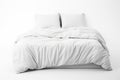 A bed with a white comforter and pillows. Comforter mockup.