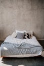 bed with white and grey linens against the background of the wall. Royalty Free Stock Photo