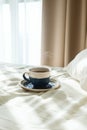 Bed with white sheets and pillow and cup of hot tea or coffee Royalty Free Stock Photo