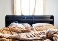 Bed with window in the morning with a guy sleeping, selective focus on blanket at front, with bright natural light from window Royalty Free Stock Photo