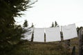 Bedclothes hanging on washing line near wooden fence outdoors