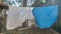 Bedding sheets drying on the clothesline outside. Lens flare. Bed linen drying on a clothes line in the garden. Royalty Free Stock Photo