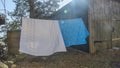 Bedding sheets drying on the clothesline outside. Lens flare. Bed linen drying on a clothes line in the garden. Royalty Free Stock Photo