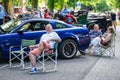 Bedford, Bedfordshire, UK June 2, 2019. People Chilling out on a sunny day at festival of motoring in front of Ford Mustang Royalty Free Stock Photo