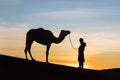 Bedouin and camel on way through sandy desert Beautiful sunset with caravan on Sahara, Morocco Desert, Africa Royalty Free Stock Photo