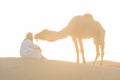 Bedouin and camel on way through sandy desert Beautiful sunset with caravan on Sahara, Morocco Desert with camel and nomads Royalty Free Stock Photo