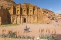 Bedouin at donkey in front of the ornate carved rock tomb known as The Monastery El Deir Nabataean ancient town Petra, Jordan.