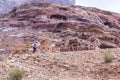 Bedouin - the driver rides a donkey and holds three camels in Petra - the capital of the Nabatean kingdom in Wadi Musa city in Jor