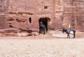 Bedouin drovers hiding from the wind with their animals in a cave in the red rocks in Petra near Wadi Musa city, Jordan