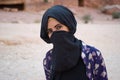 Bedouin girl, with hidden face behind veil, Petra, Jordan