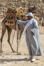 Bedouin man dressed in traditional clothes, in front of the Giza Necropolis pyramids complex. Egypt, Africa