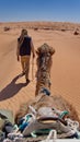 Bedouin man leading a camel on a camel trek