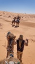 Bedouin man leading a camel on a camel trek