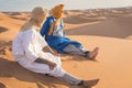 Bedouin nomad, Sahara desert, Morocco. Portrait of a Bedouin nomad with colorful turban and big smile sitting on sand dune. Royalty Free Stock Photo