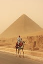 Bedouin riding camel near Great Pyramid of Khufu in a sand storm Royalty Free Stock Photo