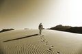 Bedouin Walking on the Sand Dunes in Wadi Rum Desert, Jordan in Sepia Colour