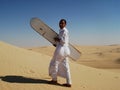 Bedouine man sand-boarding on dunes Royalty Free Stock Photo