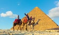 Bedouins on brightly decorated camels greet visitors of the Great Pyramids of Giza