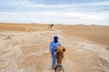 Bedouins walking with camels through yellow sands of Sahara Dessert, Morocco Royalty Free Stock Photo