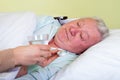 Bedridden elderly man having high temperature