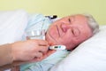 Bedridden elderly man having high temperature