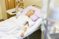 Bedridden female patient recovering after surgery in hospital care. Royalty Free Stock Photo