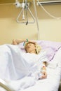 Bedridden female patient recovering after surgery in hospital care.