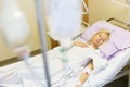 Bedridden female patient recovering after surgery in hospital care.