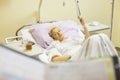 Bedridden female patient recovering after surgery in hospital care. Royalty Free Stock Photo