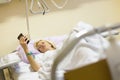 Bedridden female patient recovering after surgery in hospital care.