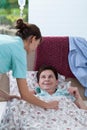 Bedridden woman and helpful nurse Royalty Free Stock Photo